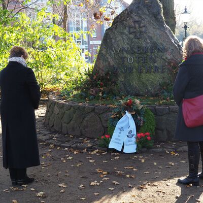 Bürgervorsteherin Harmuth und Bürgermeisterin Kruse-Gobrecht legen am Volkstrauertag den Kranz am Ehrenmal in Gedenken an die Opfer von Krieg, Gewalt und Verfolgung nieder.