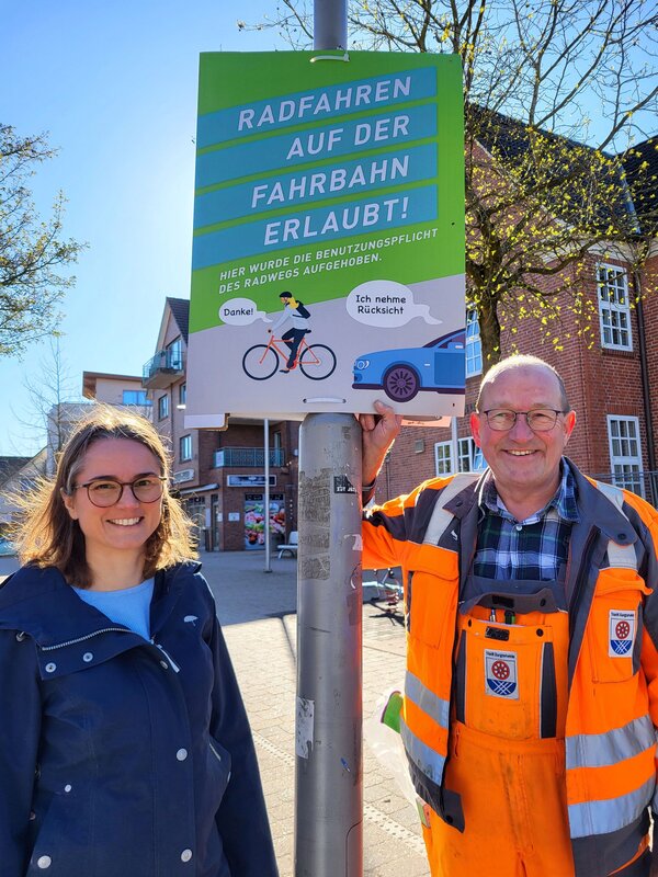 Jens Ahnfeldt vom st&auml;dtischen Bauhof bringt f&uuml;r Mobilit&auml;tsmanagerin Natascha P&auml;tzold die Plakate an.