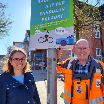Jens Ahnfeldt vom st&auml;dtischen Bauhof bringt f&uuml;r Mobilit&auml;tsmanagerin Natascha P&auml;tzold die Plakate an. 