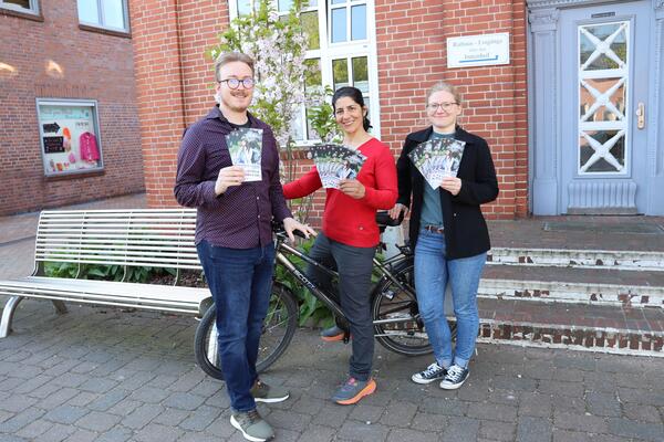Radeln fr das Klima: Rathausmitarbeiter Oliver Hahlbrock und die Klimamanagerinnen Sarah Zarin und Yasmin Eger halten die neuen Flyer in der Hand.